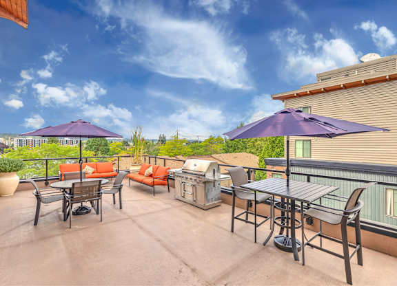 A patio with a table and chairs and umbrellas.