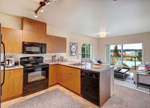A kitchen with wooden cabinets and a black oven.