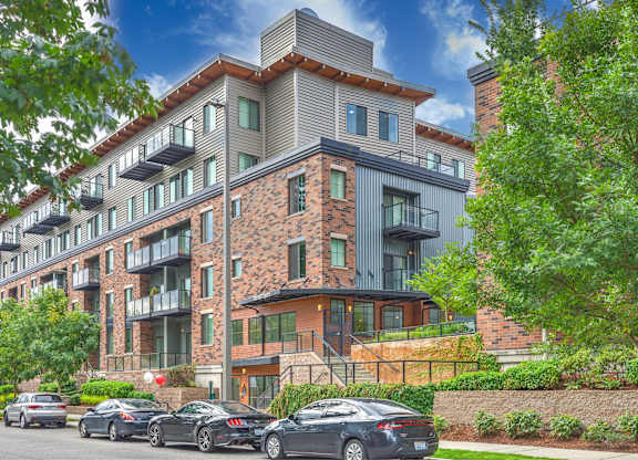 A modern apartment building with cars parked in front.
