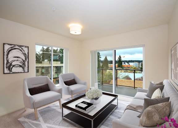 A living room with a grey couch, two chairs and a coffee table.