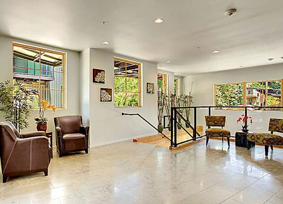 A living room with a staircase and a plant.