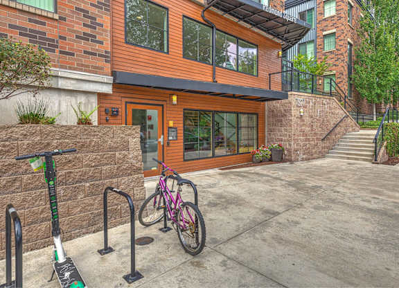 A modern house with a bicycle and a scooter parked in front.