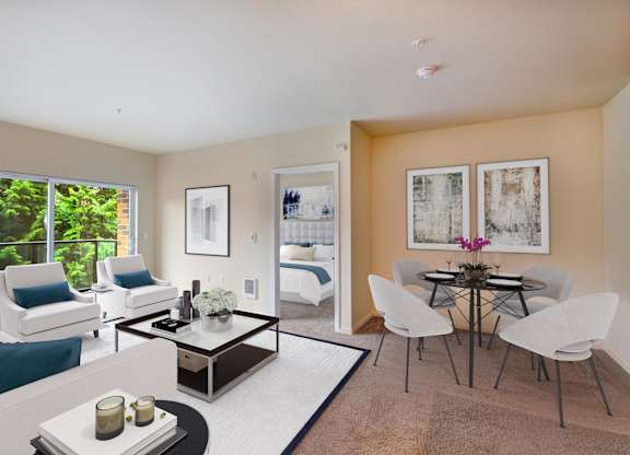 A living room with a white couch, a coffee table, and a dining table with chairs.