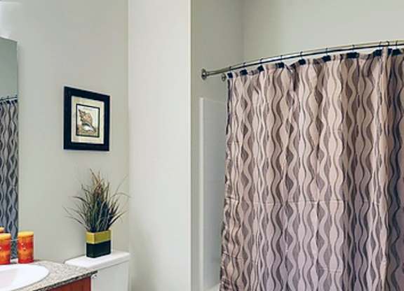 A bathroom with a toilet, sink, and shower curtain.