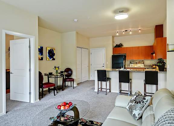 A living room with a white couch and a bar area.
