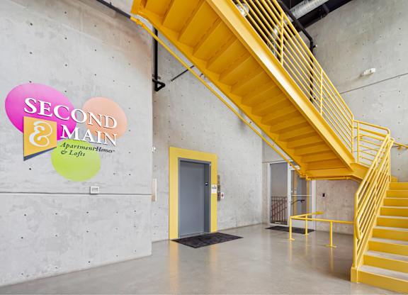 A staircase with a yellow railing and steps leads up to a door.