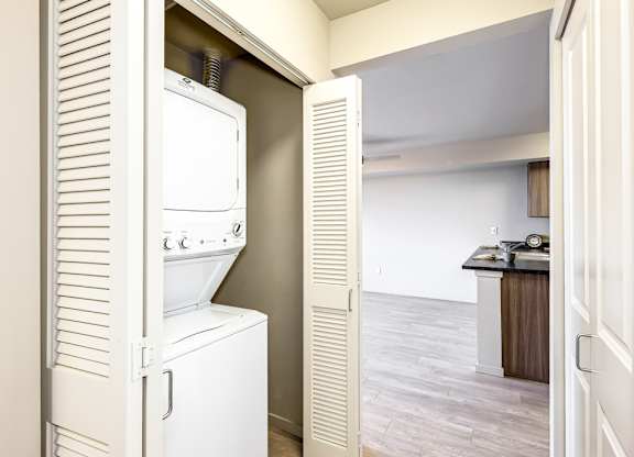 A white refrigerator is in a kitchen next to a white door.
