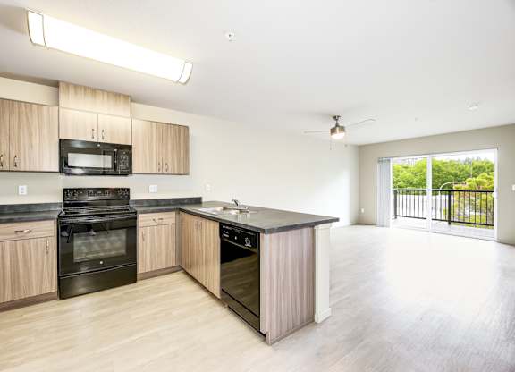 A kitchen with wooden cabinets and black appliances.