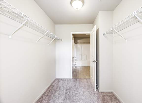A hallway with white walls and a carpeted floor.
