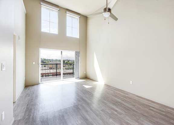 A room with a balcony and a ceiling fan.