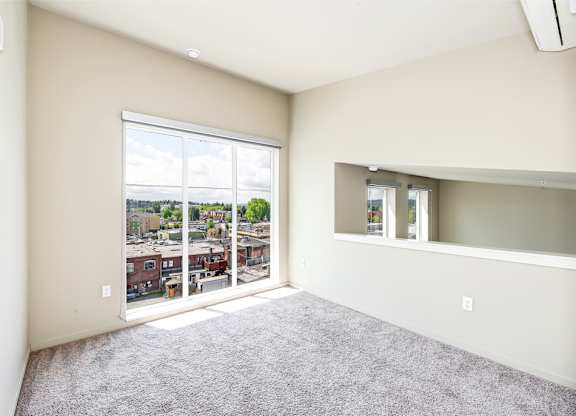 A room with a large window overlooking a cityscape.