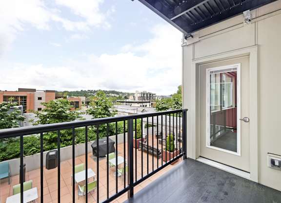A balcony with a black railing and a white door.