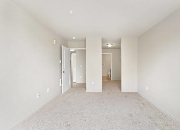 A white room with a carpeted floor and white walls.