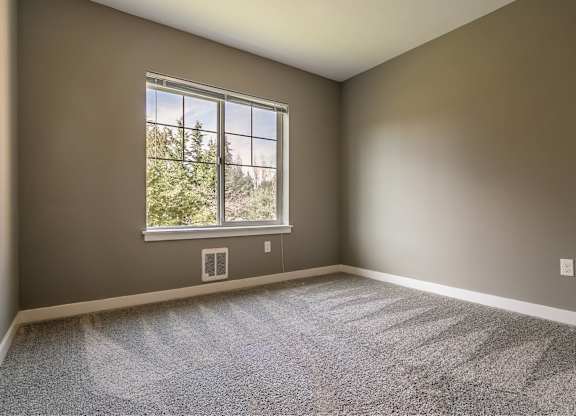 A room with a large window and carpeted floor.