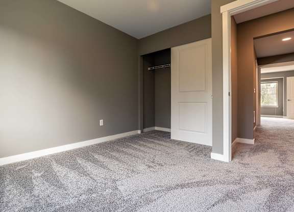 A room with a carpeted floor and a white door.