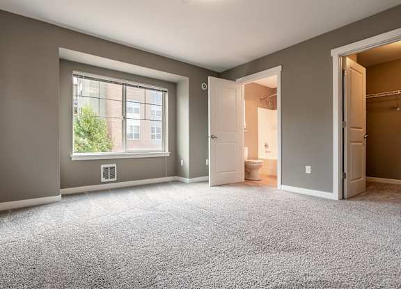 A room with a carpeted floor and a window.