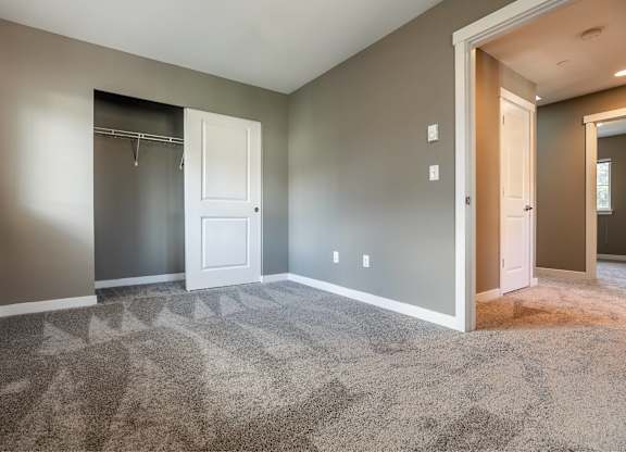 A room with a carpeted floor and a white door.