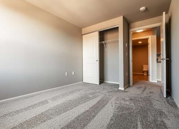 A room with a striped carpet and a white door.