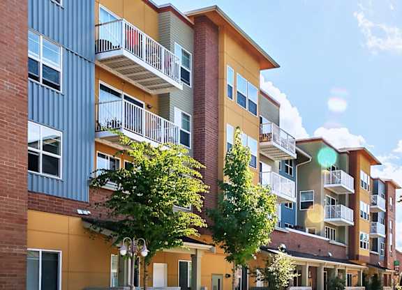 A sunny day at a modern apartment complex with a clear blue sky.