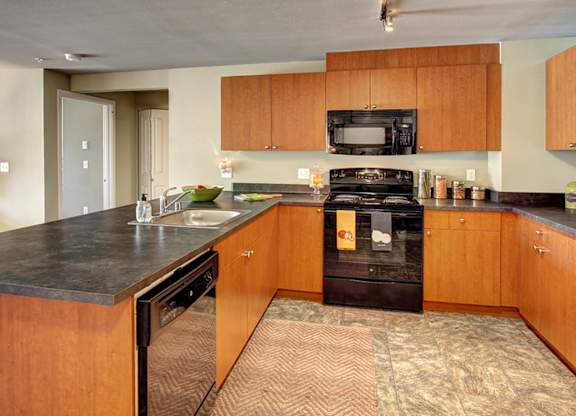 A kitchen with wooden cabinets and a black stove top oven.