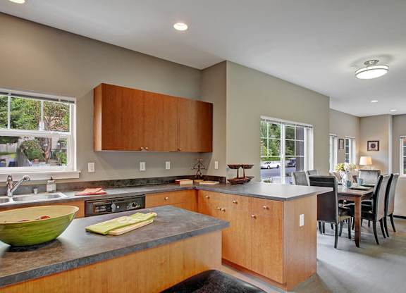 A kitchen with wooden cabinets and a green bowl on the counter.