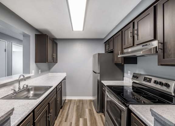 A kitchen with a stove top oven and a sink.