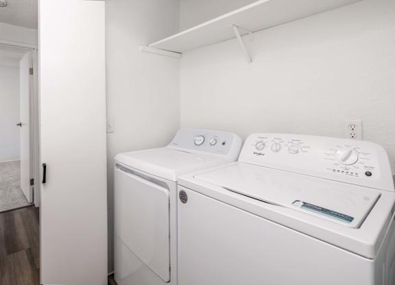A white washing machine and dryer in a small room.