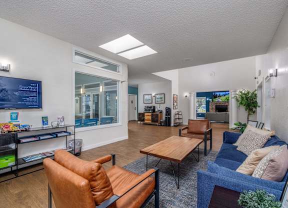 A living room with a blue couch and a brown leather chair.