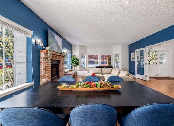 A dining room with a black table and blue chairs.