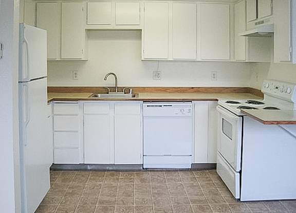 A kitchen with white appliances and cabinets.