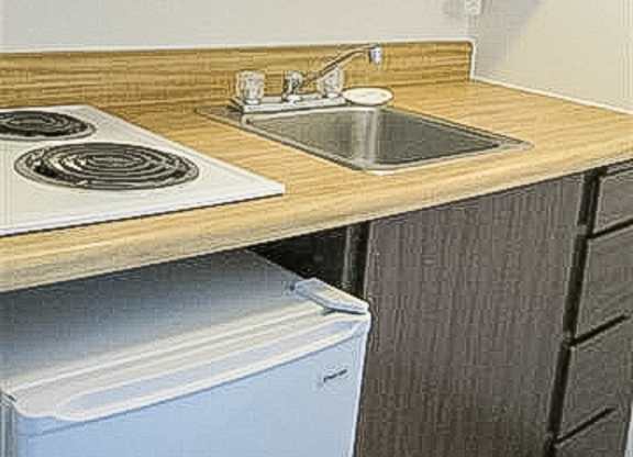 A kitchen with a stove top oven and a sink.