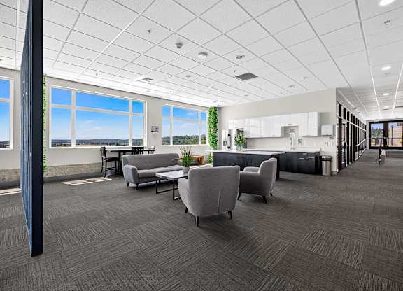 A spacious office with grey carpeting and furniture.