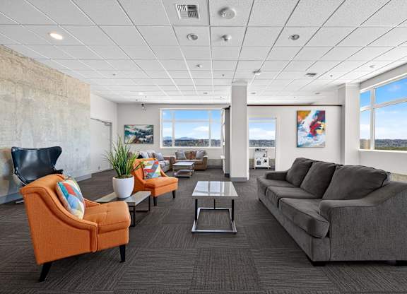 A living room with a grey couch, orange armchair, and a coffee table.