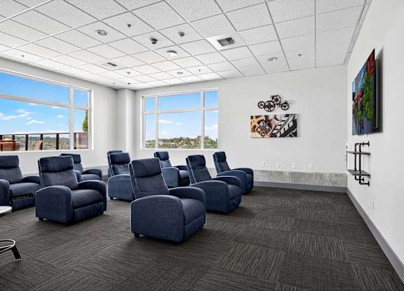 A room with blue chairs and a painting on the wall.