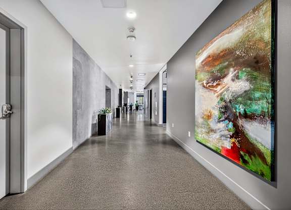 A long hallway with a painting on the wall.