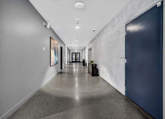 A long hallway with a blue door on the right.
