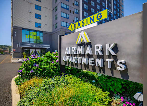 A sign for Airmark Apartments in front of a building with a