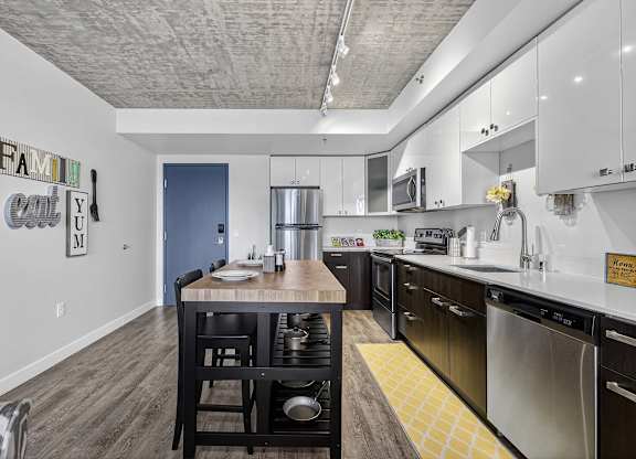 A kitchen with a dining table and chairs.