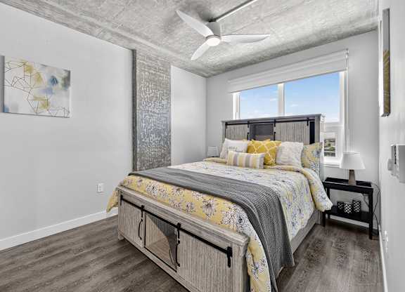 A bedroom with a large bed and a ceiling fan.