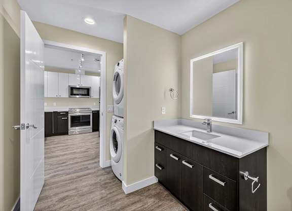 A modern laundry room with a washer and dryer built into the cabinetry.