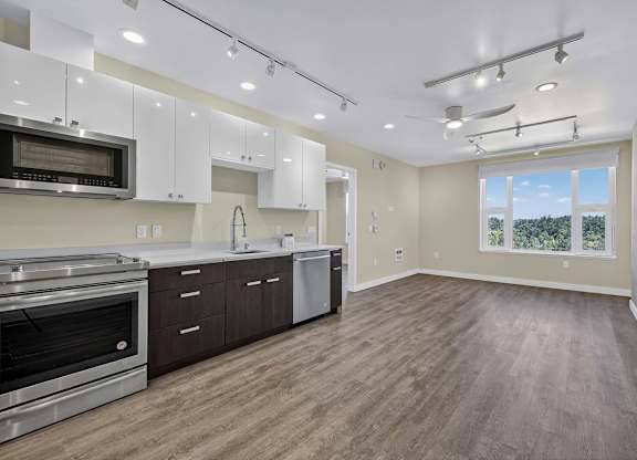 A spacious kitchen with wood flooring and stainless steel appliances.