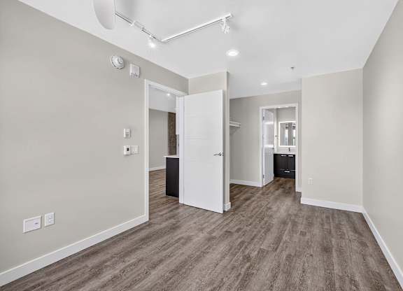 A room with a white door and a brown floor.