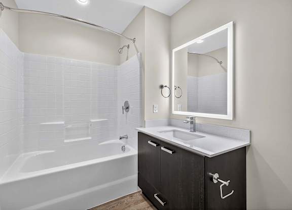 A white bathroom with a white tub and sink.