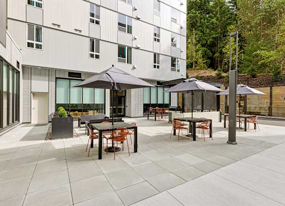 A patio with a table and chairs is in front of a white building.