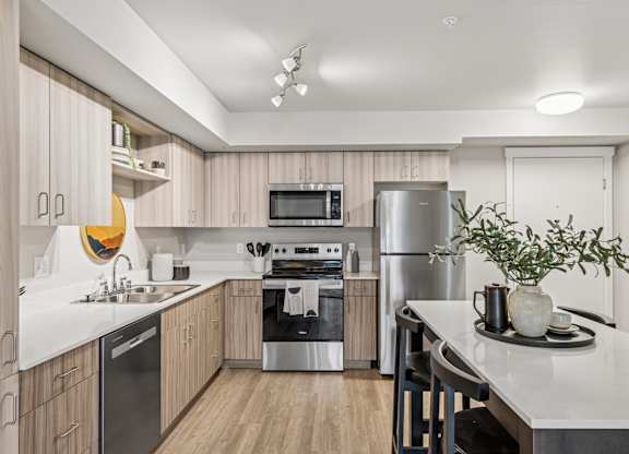 A modern kitchen with wooden cabinets and stainless steel appliances.