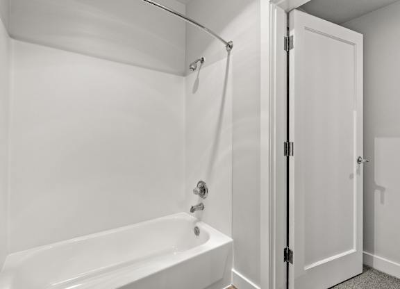 A white bathroom with a tub and shower.