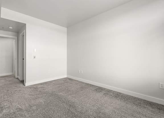 A room with a carpeted floor and white walls.