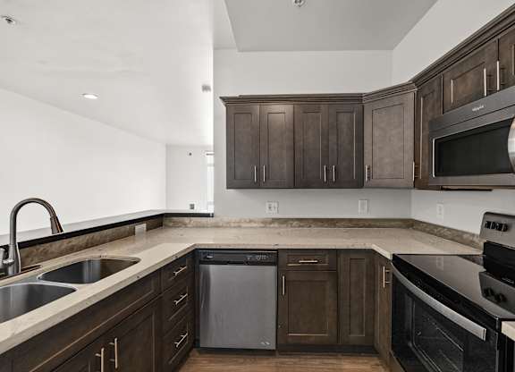 A kitchen with dark wood cabinets and stainless steel appliances.