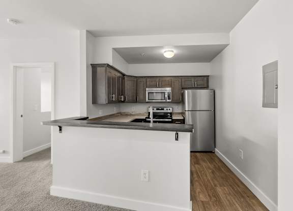 A kitchen with a white countertop and a stainless steel refrigerator.