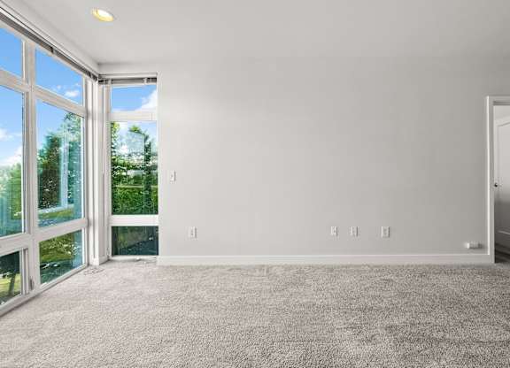 A room with a carpeted floor and a sliding glass door.